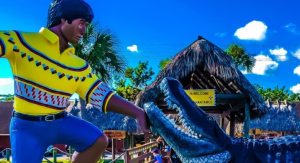 Image: A sculpture depicting a Miccosukee man with an alligator at the entrance to the Miccosukee Indian Village