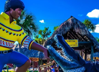 Image: A sculpture depicting a Miccosukee man with an alligator at the entrance to the Miccosukee Indian Village