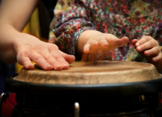 Hispanic Heritage in Miami | More Than Just a Month Image: A parent plays a bongo drum with their young child