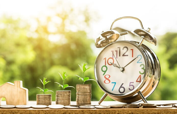 Image: An alarm clock next to stacks of quarters
