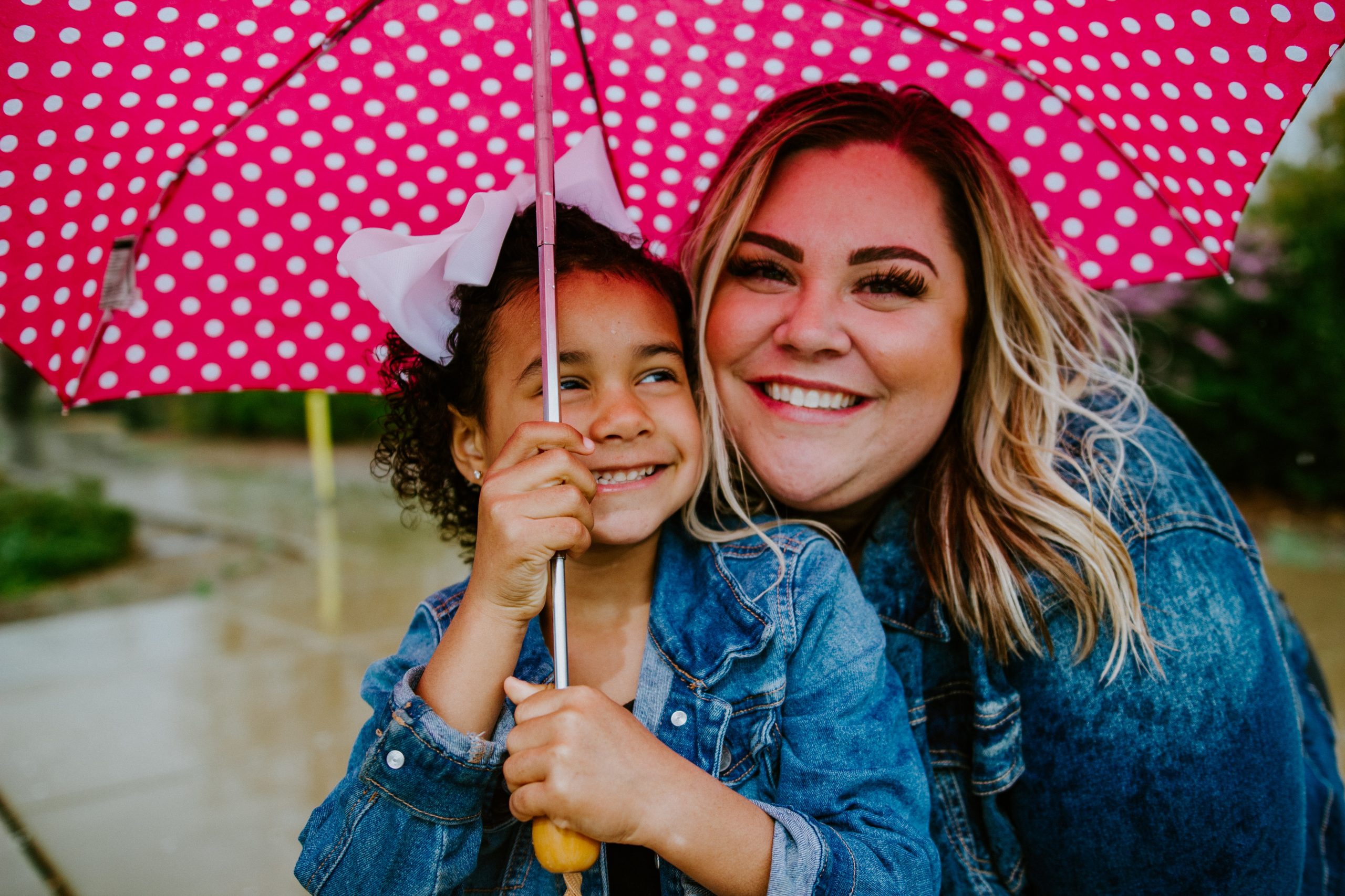 Image: A mother and daughter share smiles and an umbrella