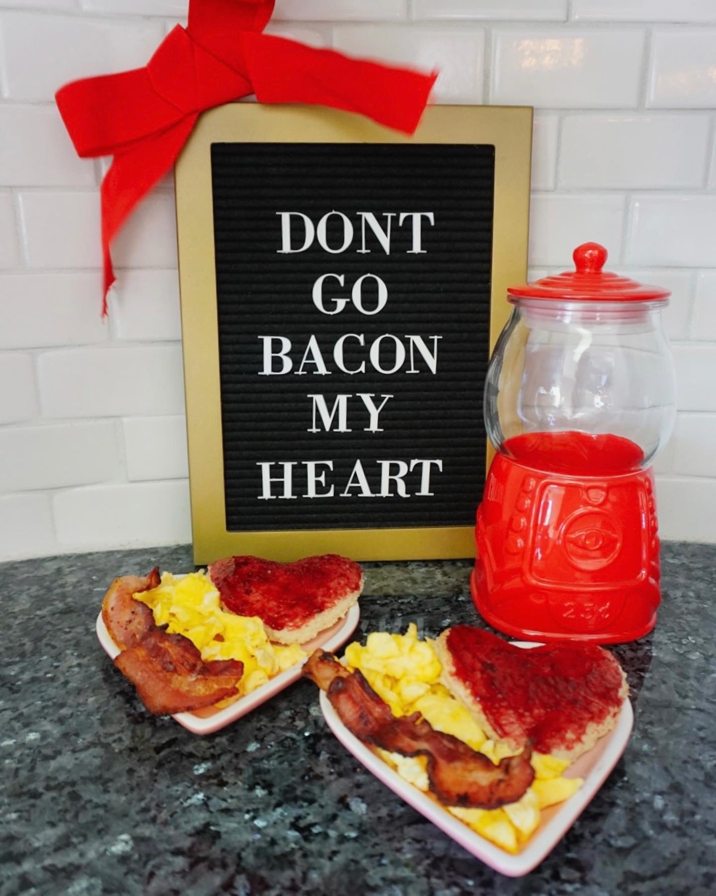 Heart-shaped pancakes, eggs, and bacon on heart-shaped plates