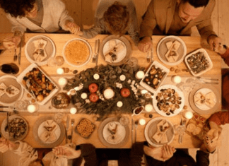 A large family gathered around the dinner table (Family Mealtime is the Heart of the Home Holly Farver Contributor Miami Mom Collective)