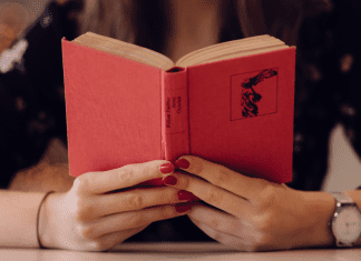 A woman holding an open book (Let's Celebrate: National Reading Across America Day Lorena Lougedo Contributor Miami Mom Collective)