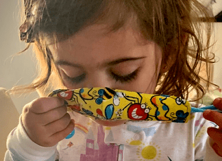 A toddler putting a mask on (Wear a Mask: How To Get Your Toddler to Wear One (and Keep It On!) Alexa Gonzalez Contributor Miami Mom Collective)