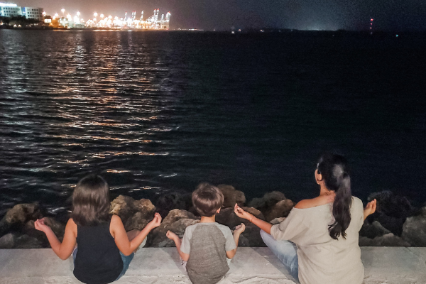 Minnie and her kids sitting by the water (Minerva Roca Contributor Miami Mom Collective)
