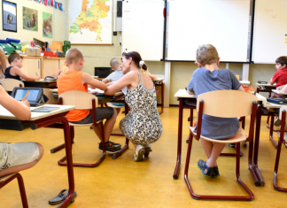 A teacher helping a student in a classroom (Teacher Appreciation Week: Let's Show Appreciation Lorena Lougedo Contributor Miami Mom Collective)