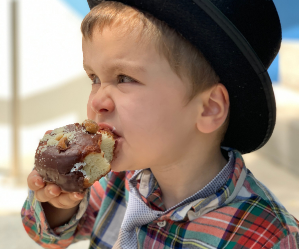 "How I Went Gluten-Free" Image: a young boy bites into a chocolate covered donut. (How I Went Gluten-Free Brittany Aquart Contributor Miami Mom Collective)