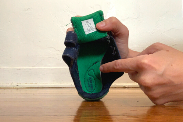 Image: Brittany checking the sole of a shoe (Brittany Aquart Contributor Miami Mom Collective)