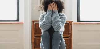 Speak Up: You Matter, Your Opinions Matter Image: A woman sitting down with her head in her hands (Speak Up: You Matter, Your Opinions Matter Rachelle Haime Contributor Miami Mom Collective)