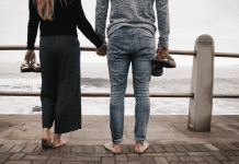 Image: A couple standing side by side on a pier