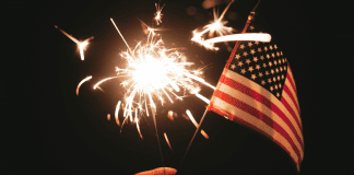 A sparkler and an American Flag (Fireworks: What to Do and Where to See Them in Miami on the 4th of July Bella Behar Contributor Miami Mom Collective)