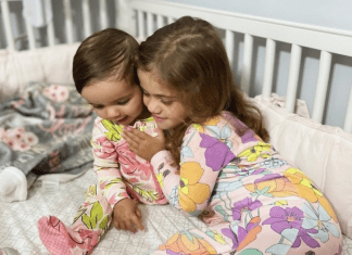 Image: Two sisters snuggling in a crib (A New Roommate and a New Bed (All at Once!): Our Experience Alexa Gonzalez Contributor Miami Mom Collective)