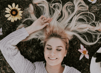 National Wellness Month: 6 Easy Ways to Prioritize Your Wellness Today A woman relaxing in field of flowers (National Wellness Month: 6 Easy Ways to Prioritize Your Wellness Today Rachelle Haime Contributor Miami Mom Collective)