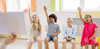 A group of children raising their hands (Your Child Votes YES! Getting Involved at Your Child's School Matters! Holly Farver Contributor Miami Mom Collective)