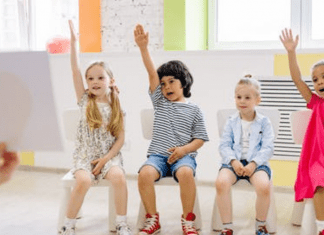 A group of children raising their hands (Your Child Votes YES! Getting Involved at Your Child's School Matters! Holly Farver Contributor Miami Mom Collective)