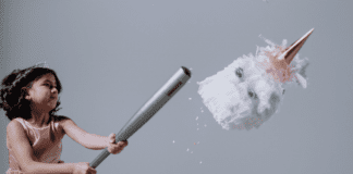 A girl hitting a pinata (Hispanic Heritage Month: Ways to Celebrate Lorena Lougedo Contributor Miami Mom Collective)