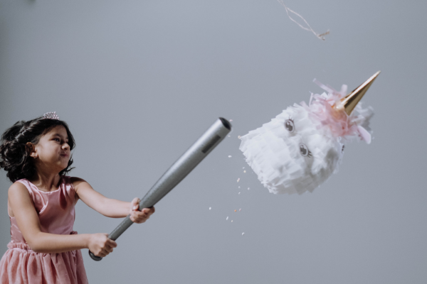 A girl hitting a pinata (Hispanic Heritage Month: Ways to Celebrate Lorena Lougedo Contributor Miami Mom Collective)