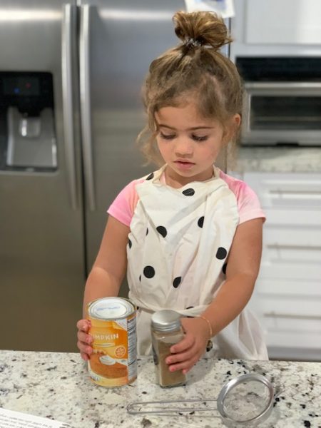 Image: A little girl helps her mom in the kitchen
