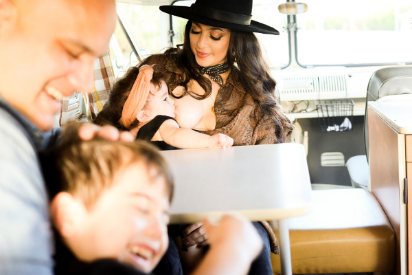 Image: Jacqueline nurses her daughter while her husband and son play in the foreground (Weaning My Toddler Cold Turkey & Facing My Fear Jacqueline Jebian Garcia Contributor Miami Mom Collective)
