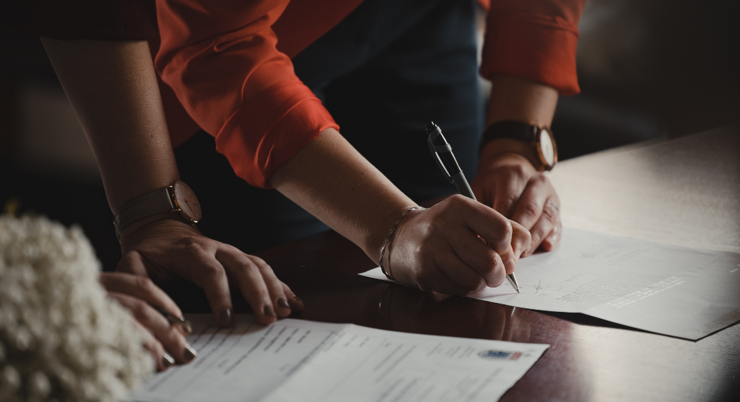 A couple signing documents (Designation of Health Care Surrogate for A Minor: What You Should Know Kristina Hernandez Tilson Contributor Miami Mom Collective)