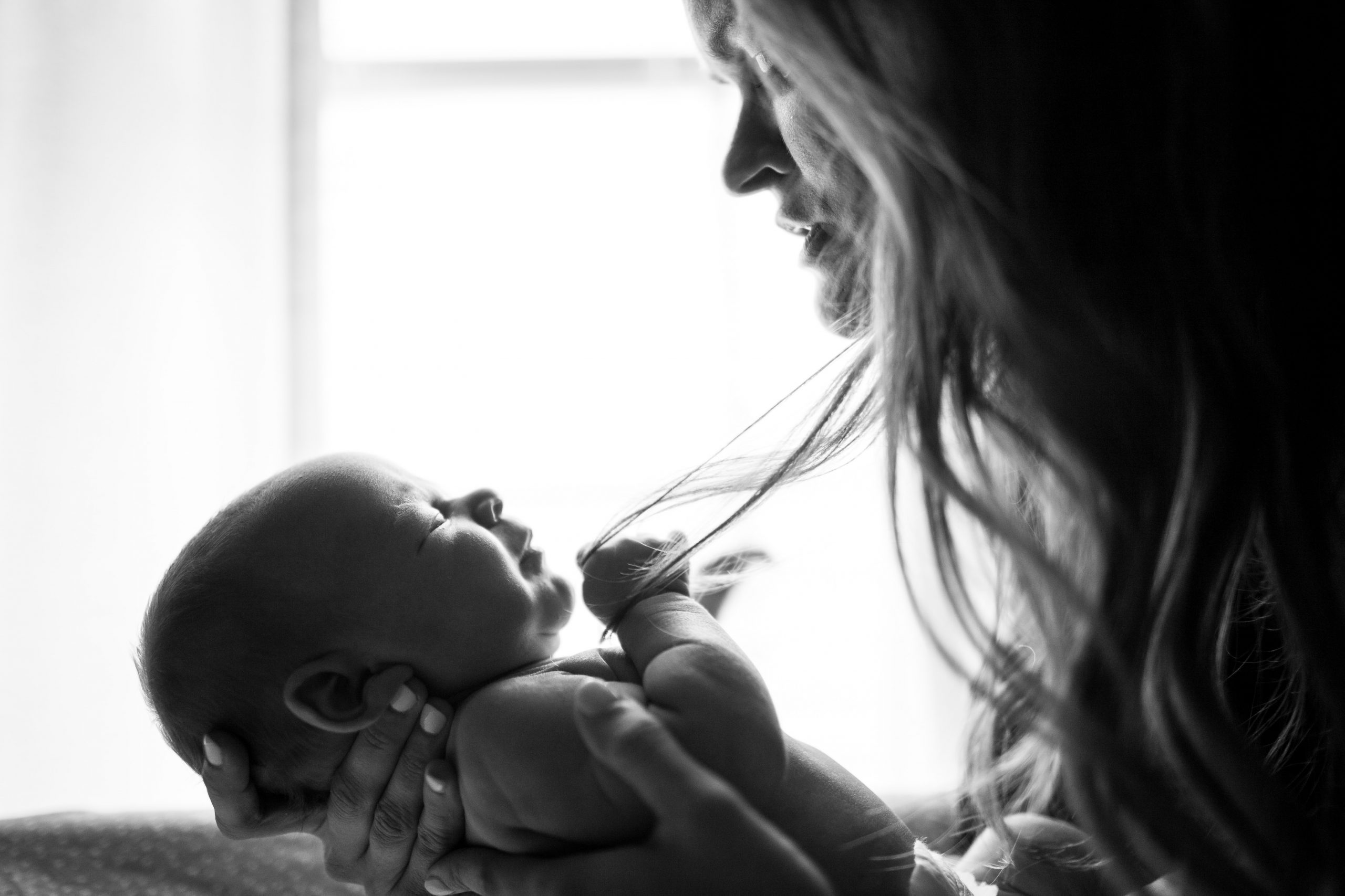 A mother holding her infant (To Parent in a Broken World Kristin Parke Contributor Miami Mom Collective)