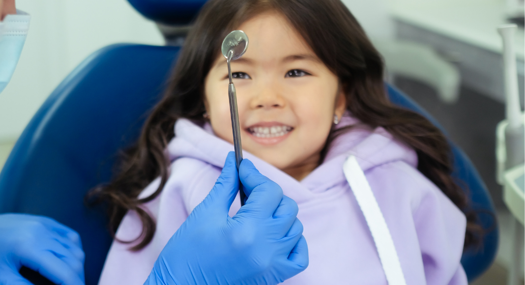 A young girl at the dentist's office (Going Back to the Dentist? 3 Things to Consider | Dr. Bob Pediatric Dentist Lynda Lantz Contributor Miami Mom Collective)