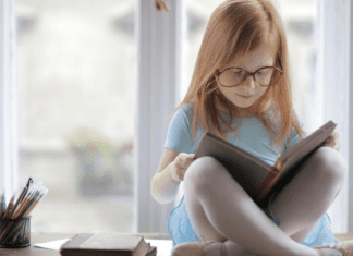 Image: A little girl reading a book (October is Dyslexia Awareness Month Sharonda Stewart Contributor Miami Mom Collective)