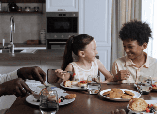 Image: A family sitting around the dinner table (How to Deal With a Picky Eater Dina Garcia Contributor Miami Mom Collective)