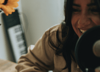 Image: A woman hosting a podcast (Listening for My Sanity: My Top 10 Podcasts Alisa Britton Contributor Miami Mom Collective)