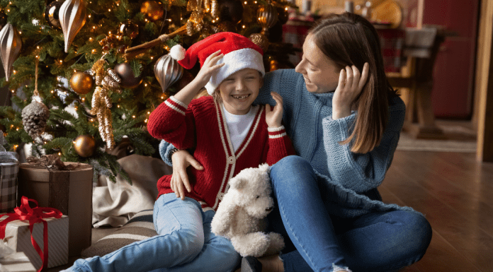 Image: A mother and daughter sitting in front of their Christmas tree