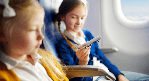 Image: Two girls sitting together on an airplane (Holiday Travel: The Ultimate Prep List for Smooth Family Travel Vanessa Santamaria Contributor Miami Mom Collective)