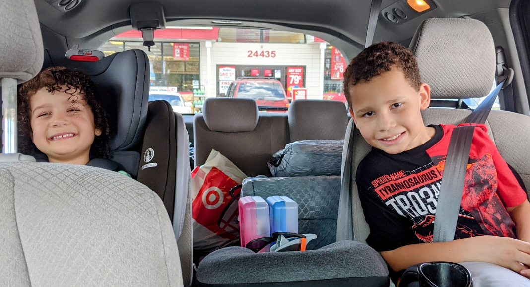 Image: Two kids in their car seats ready for a family road trip (Holiday Travel: 3 Ways to Balance Structure & Spontaneity | Dr. Bob Lynda Lantz Editor Miami Mom Collective)