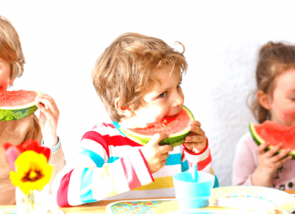 Three children enjoying slices of watermelon as a healthy snack