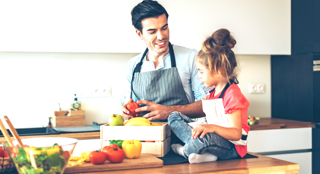 A father and daughter prepare a salad together