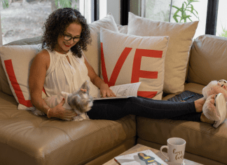 Image: Adita relaxing on her couch with a book (Mama, It's Time to Prioritize YOU! Adita Lang Contributor Miami Mom Collective)