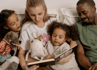 Image: A multi-racial family sitting a reading a book together