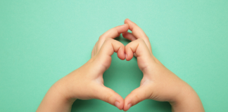 Image: A child makes a heart with their hands