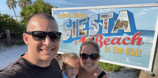 Holly's son with his family in front of a Siesta Beach sign
