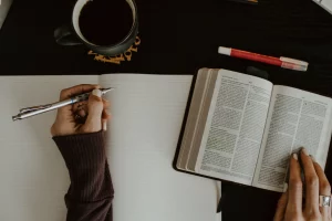 A woman journaling with an open Bible