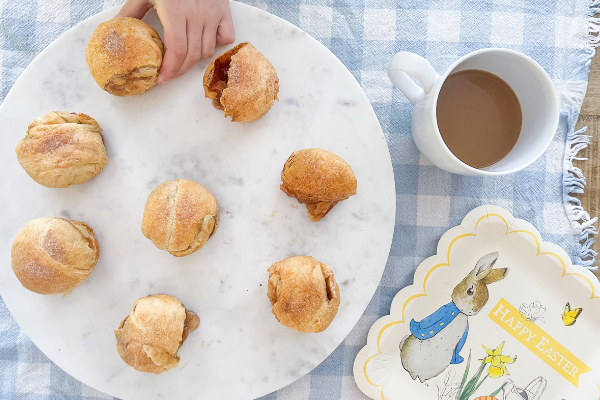 Image: Child's hand taking a Resurrection Roll off of a plate to enjoy