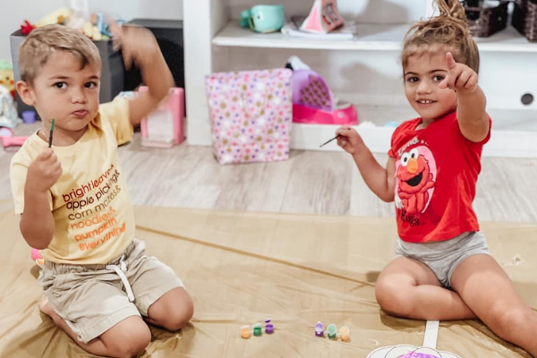 Two children painting during a playdate