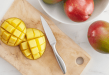 Image: A sliced mango on a wooden cutting board
