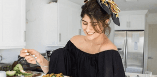 Arroz Con Gandules: A Seasonal Dish With a Twist Michele holding a plate of homemade arroz con gandules