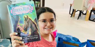 An almost middle school student holding up a new book