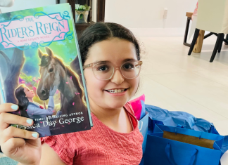 An almost middle school student holding up a new book