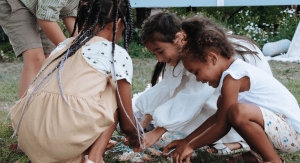 A group of children gather pieces of candy from a broken pinata