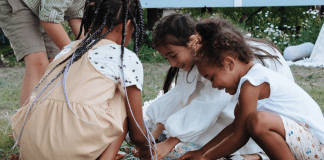 A group of children gather pieces of candy from a broken pinata