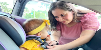 Child Passenger Safety: 5 Tips for Every Parent Mother strapping child in car seat