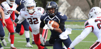 A football player runs with the ball during a play